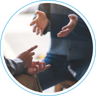 Manos gesticulando durante una conversación, representando el diagnóstico financiero y la definición de objetivos de inversión con un aseso