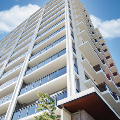 Vista de ángulo bajo de un moderno edificio de departamentos con balcones, ideal para inversión inmobiliaria en Santiago